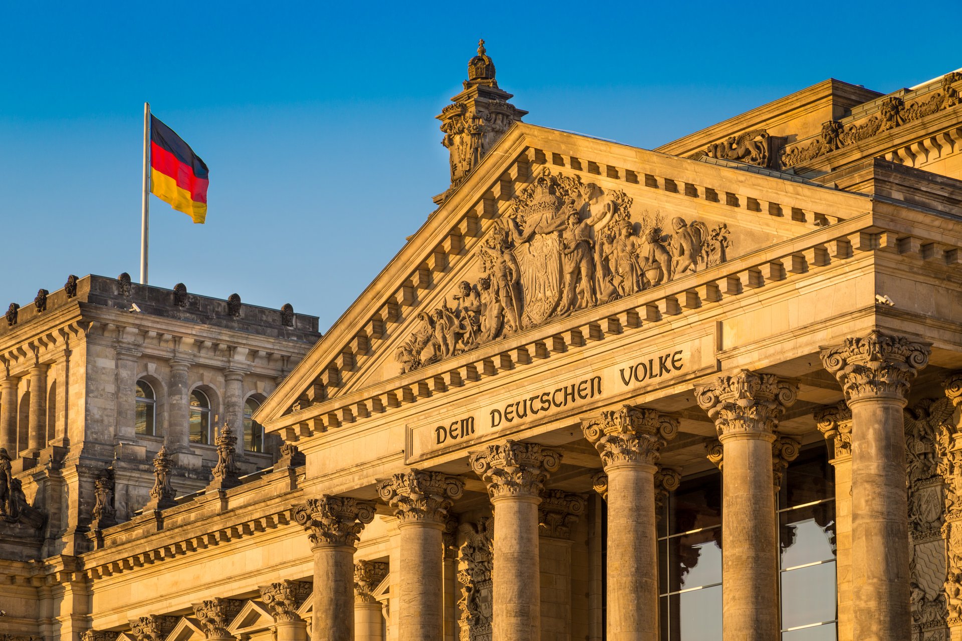 Beschreibung: Nahaufnahme des Reichstagsgebäudes mit blauem Himmel beleuchtet durch Sonnenuntergang
