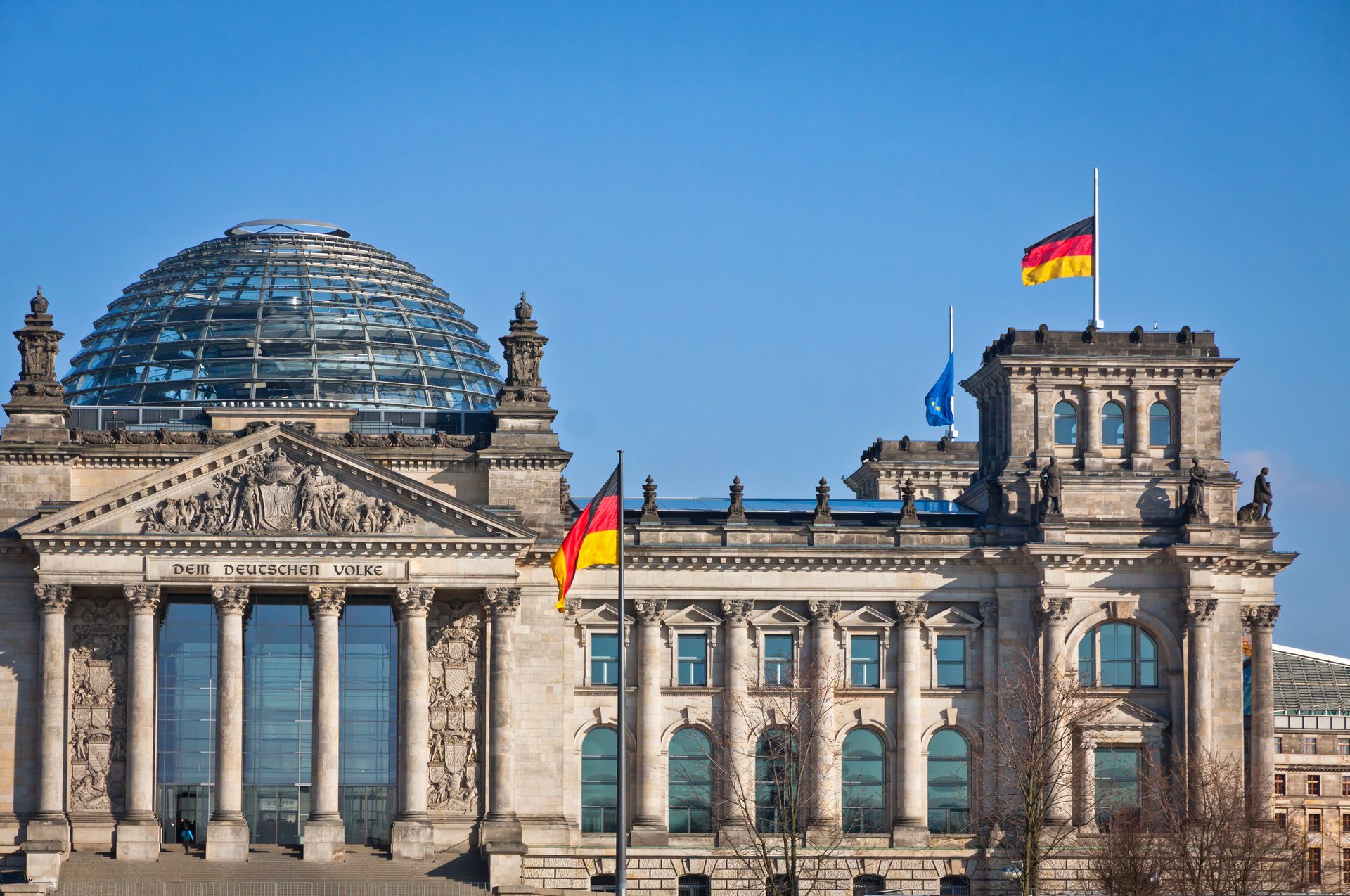 Beschreibung: Bundestag mit deutscher Flagge und blauem wolkenlosem Himmel