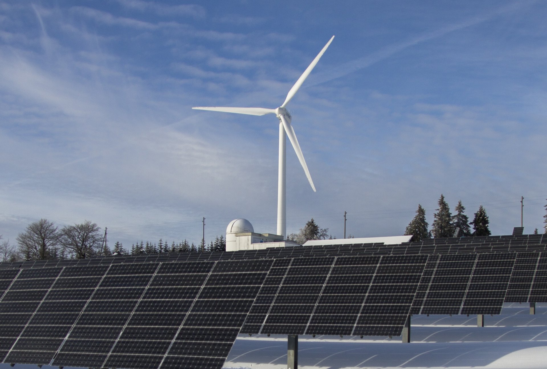 Windrad und Solarkollektoren auf einem schneeweißen Feld