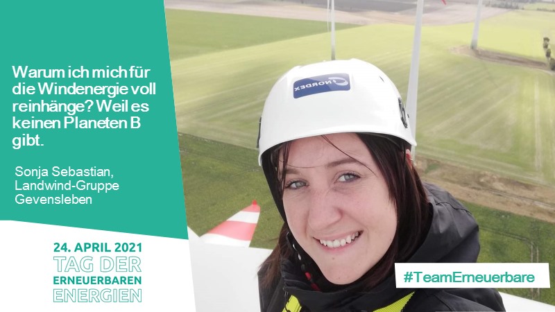 Frau mit Helm auf einer Windkraftanlage