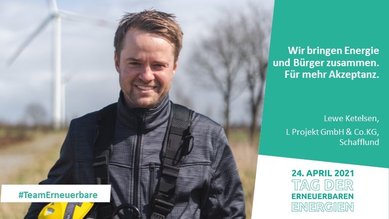 Mann mit Windkraftanlage im Hintergrund