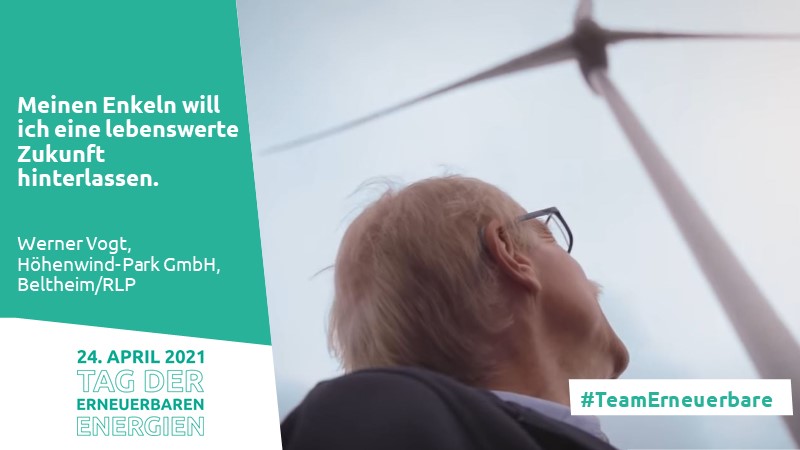 Mann guckt hoch zu einer Windkraftanlage
