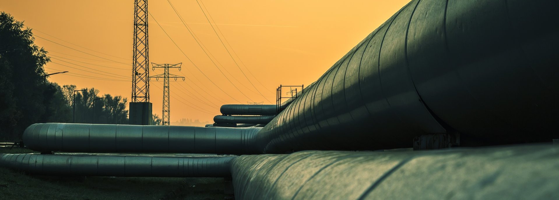 Beschreibung: Elektrische Drähte und Fernwärmerohre bei Sonnenaufgang