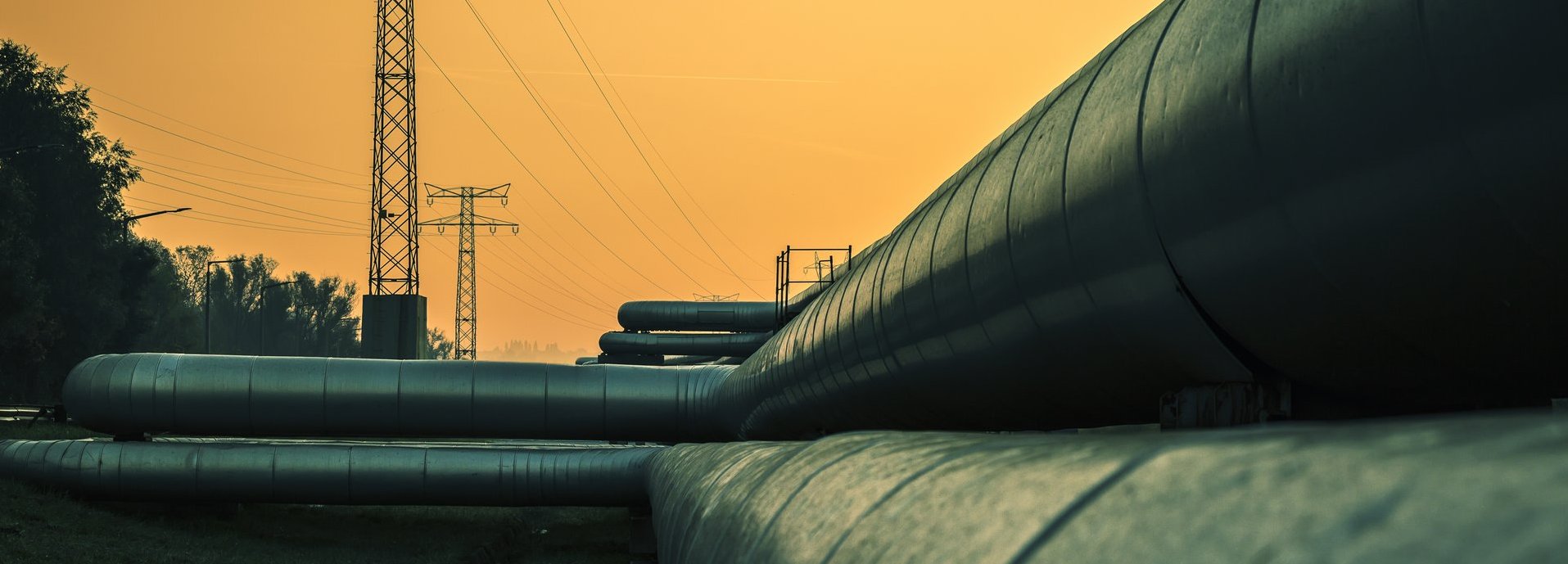 Beschreibung: Elektrische Drähte und Fernwärmerohre bei Sonnenaufgang