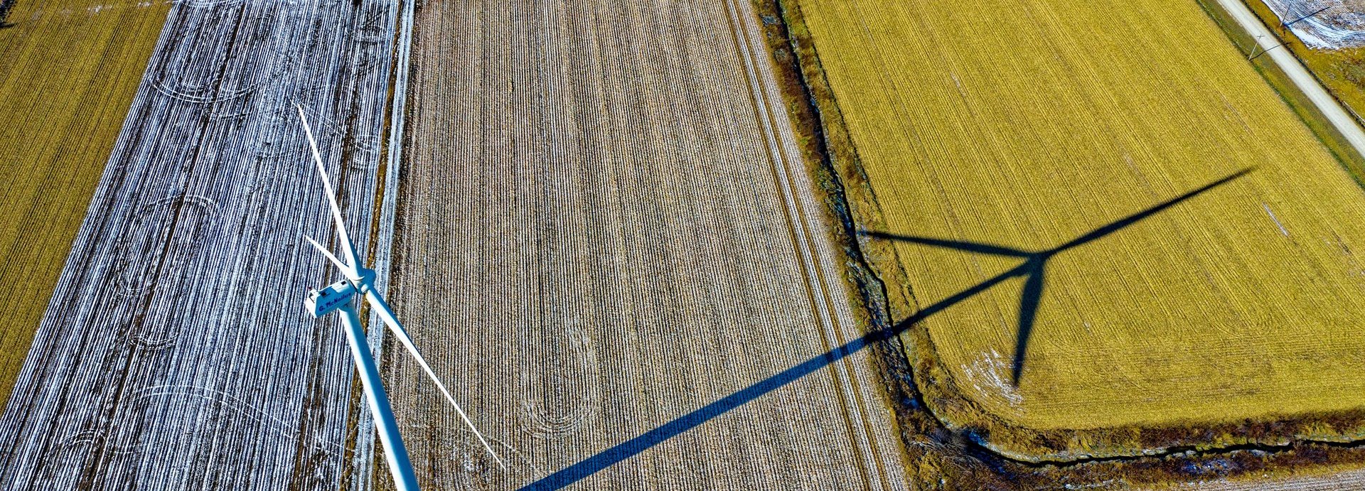 Luftaufnahme eines Windrades auf landwirtschaftlich genutztem Feld