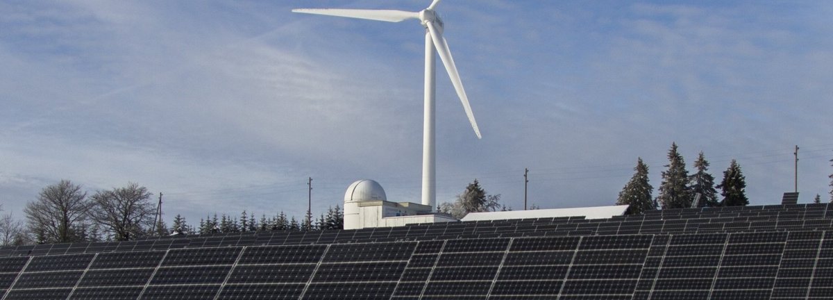 Windrad und Solarkollektoren auf einem schneeweißen Feld