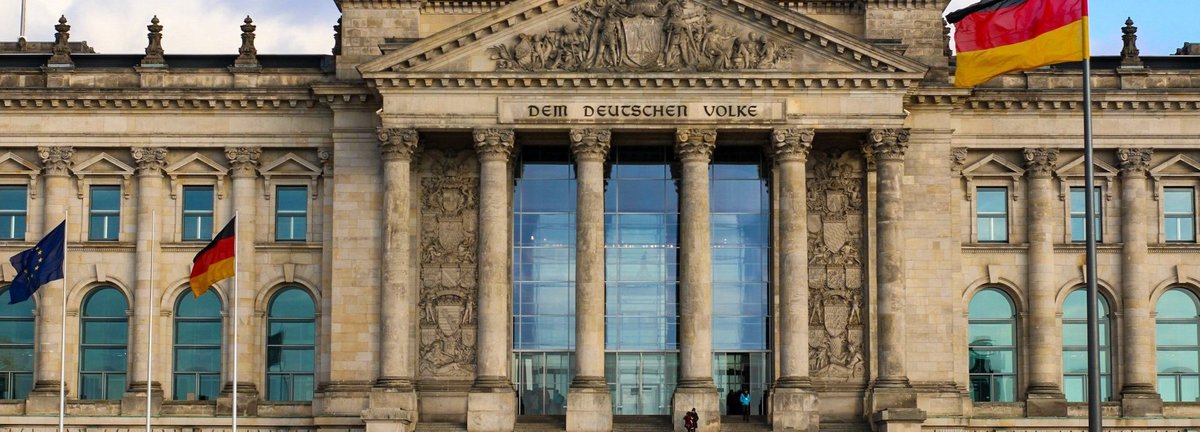 Frontalansicht auf den deutschen Bundestag vor einem bewölkten Himmel