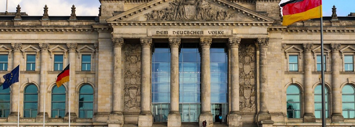 Frontalansicht auf den deutschen Bundestag vor einem bewölkten Himmel