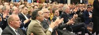 Seitenansicht Menschen sitzen in Stuhlreihen bei einer Veranstaltung und klatschen