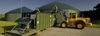 Biogasanlage mit blauem Bagger bei der Arbeit