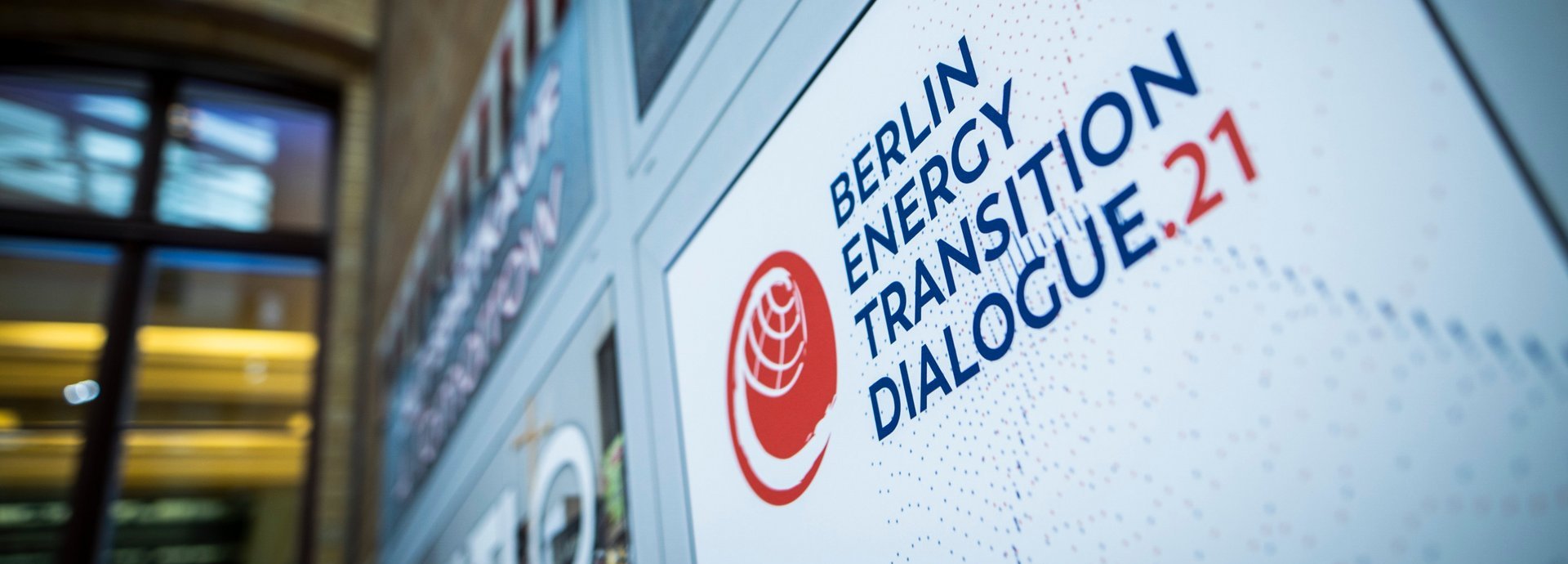 Nahaufnahme des Logo des Berlin Energy Transition Dialogue 2021 an einer Wand