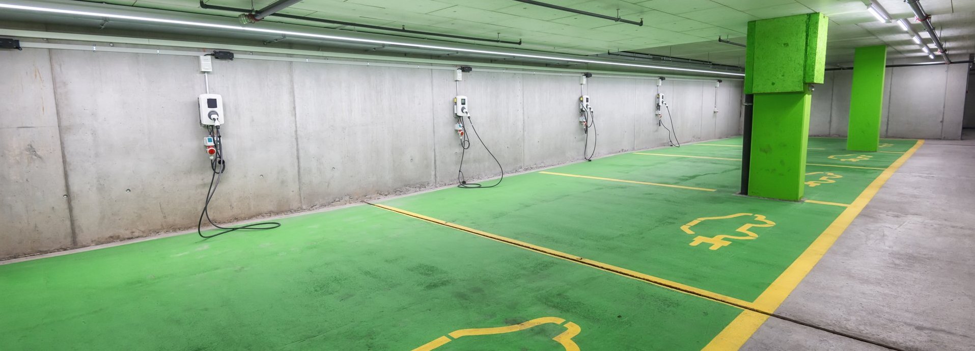 leere Elektro Ladeplätze in einer Tiefgarage mit grünen Markierungen auf dem Boden