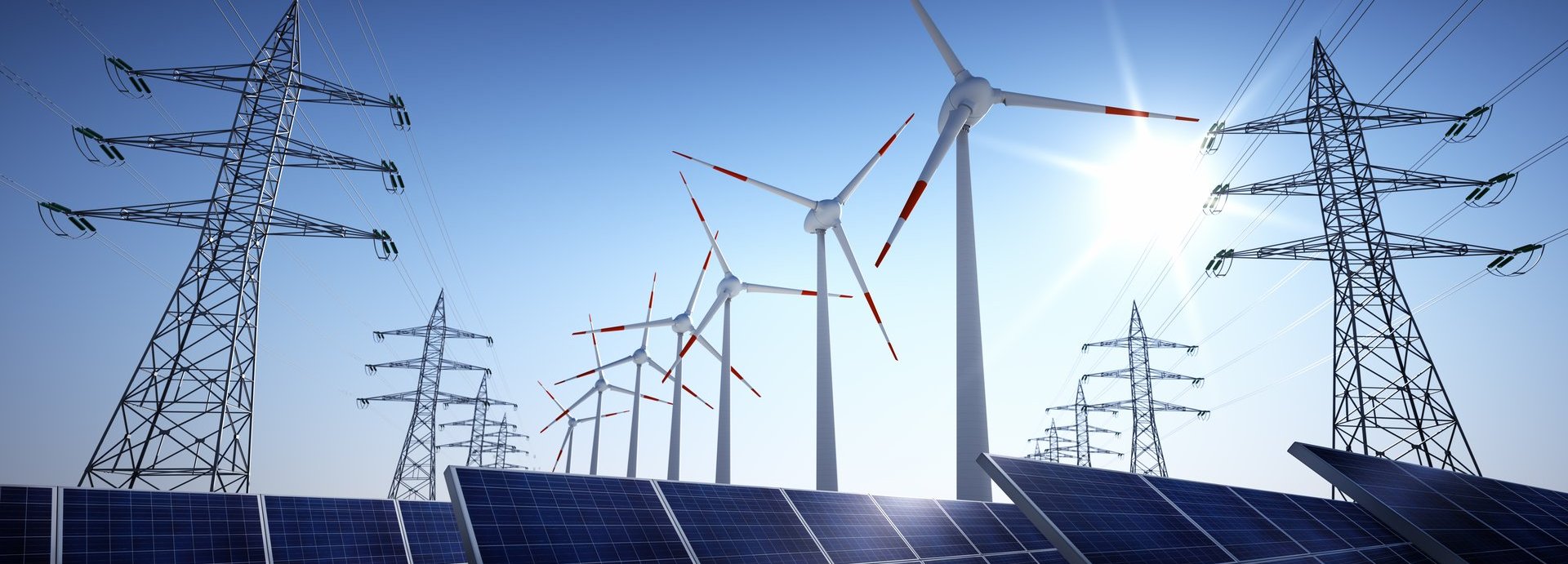 Stromleiter, Windräder und Solarzellen vor einem blauen sonnigen Himmel