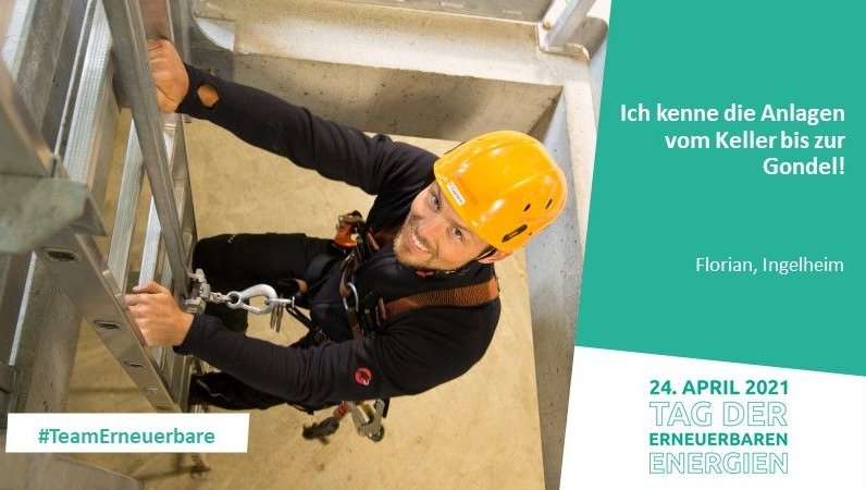 Mann mit Helm und Kletterausrüstung im Innenraum einer Windkraftanlage