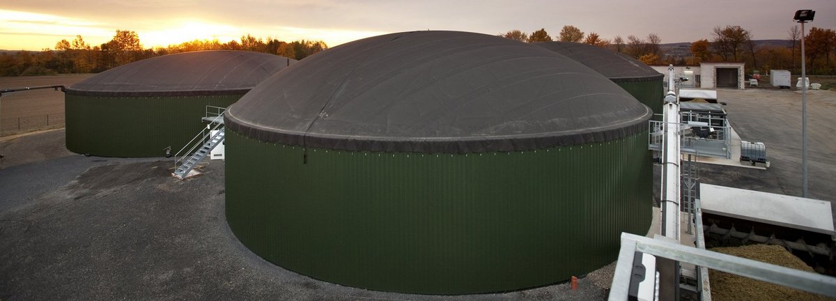 Biogasanlage Wollbrandshausen vor bewölktem Himmel und Sonnenuntergang