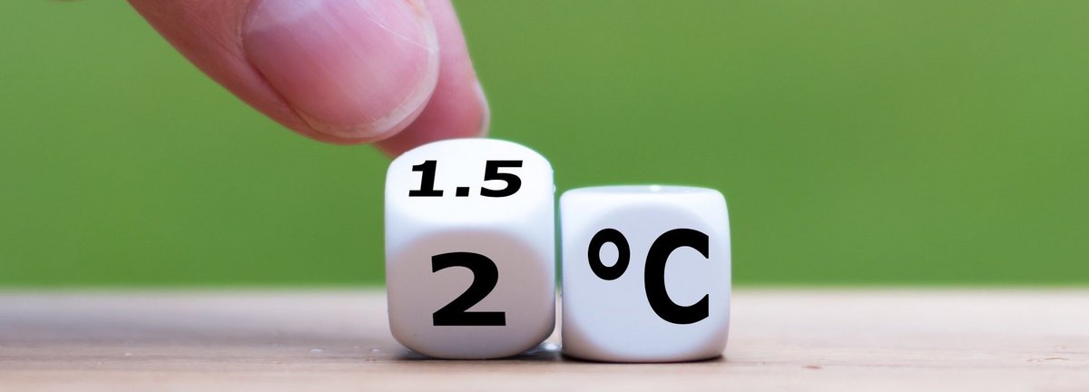 Symbol für die Begrenzung der globalen Erwärmung. Die Hand dreht einen Würfel und ändert den Ausdruck „2°C“ in „1,5°C“ oder umgekehrt.