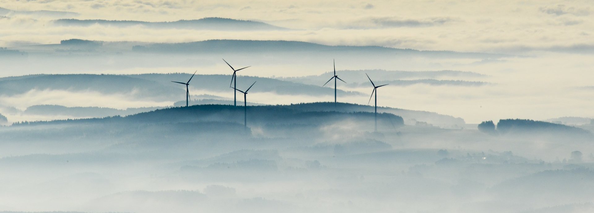 Vogelaufnahme Windräder umgeben von Nebeln oder Wolken