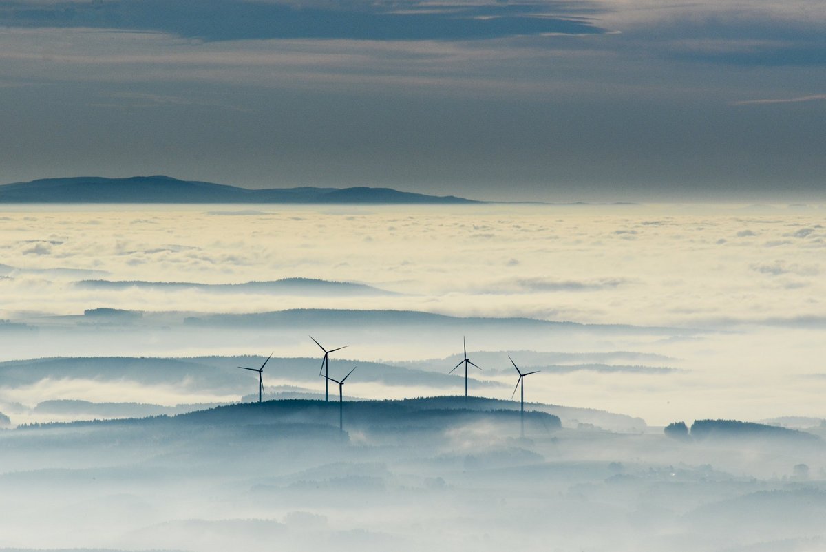 Vogelaufnahme Windräder umgeben von Nebeln oder Wolken