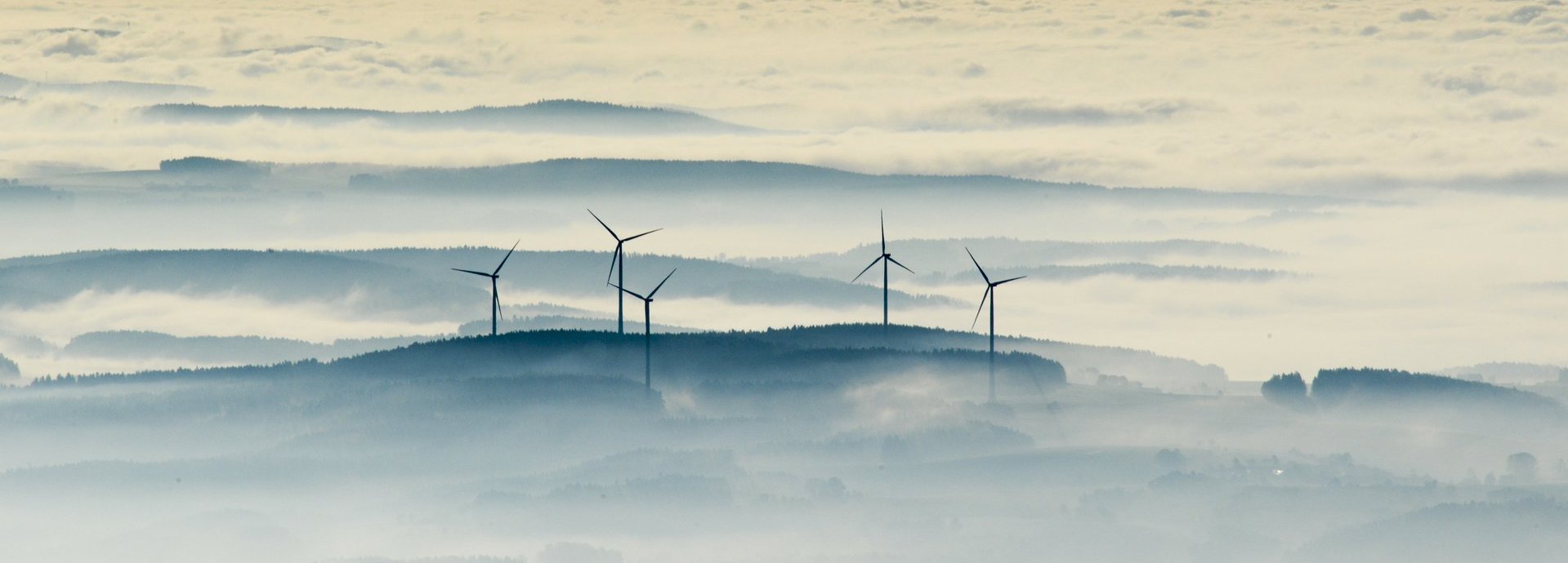 Vogelaufnahme Windräder umgeben von Nebeln oder Wolken