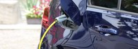 Nahaufnahme Dunkelblaues Elektroauto wird auf einem Hof geladen