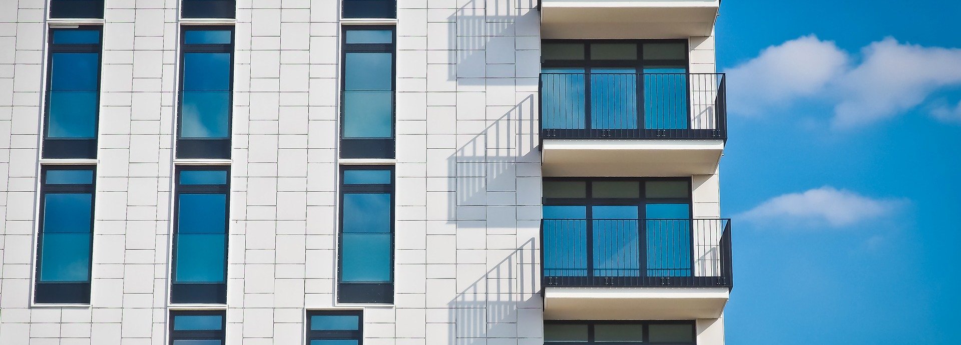 Nahansicht eines Wohnblocks mit weißer Fassade und Balkons