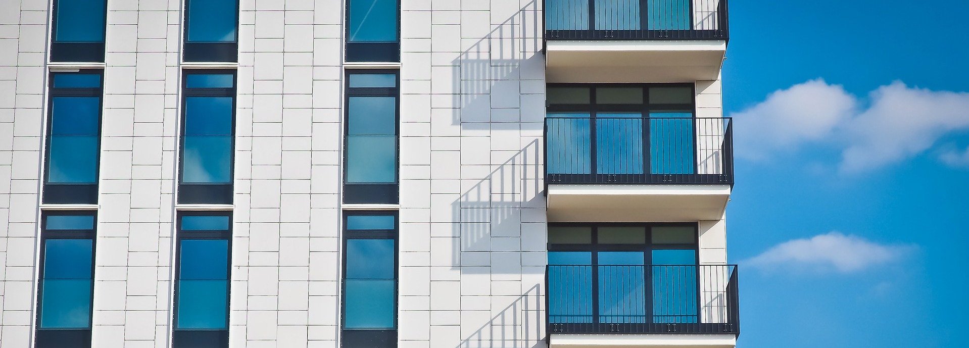 Nahansicht eines Wohnblocks mit weißer Fassade und Balkons