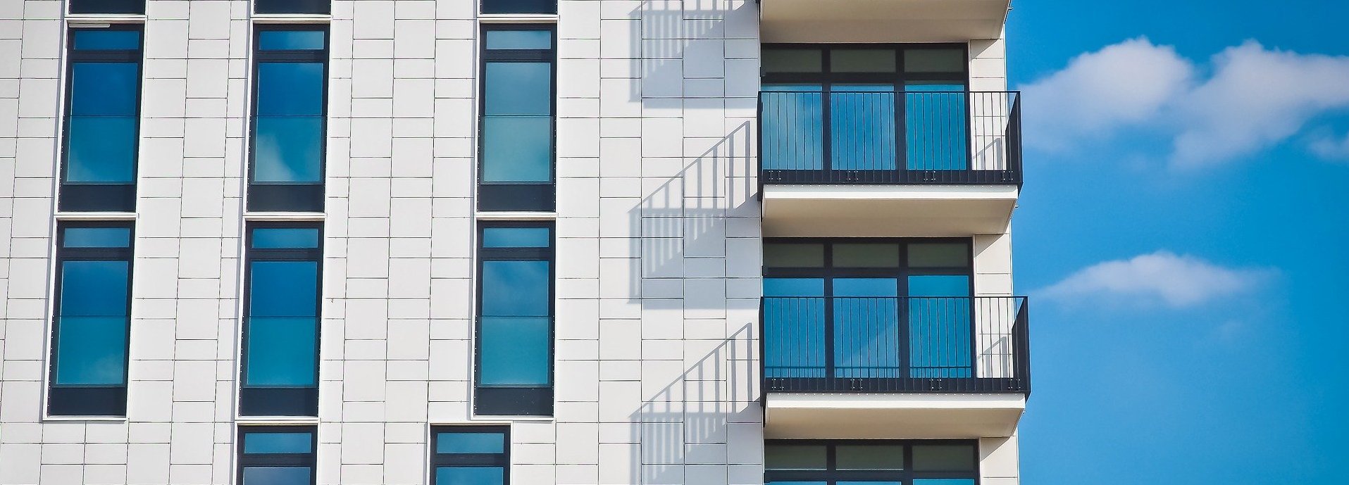 Nahansicht eines Wohnblocks mit weißer Fassade und Balkons