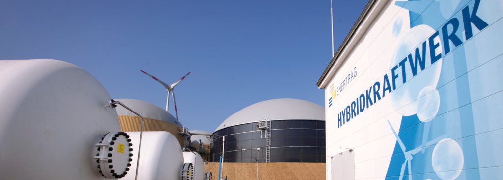 Enertrag Hybridkraftwerk mit blauem Himmel und Windrad am Horizont