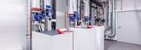 Weiße Wärmepumpe mit Rohren im Keller eines Gebäudes