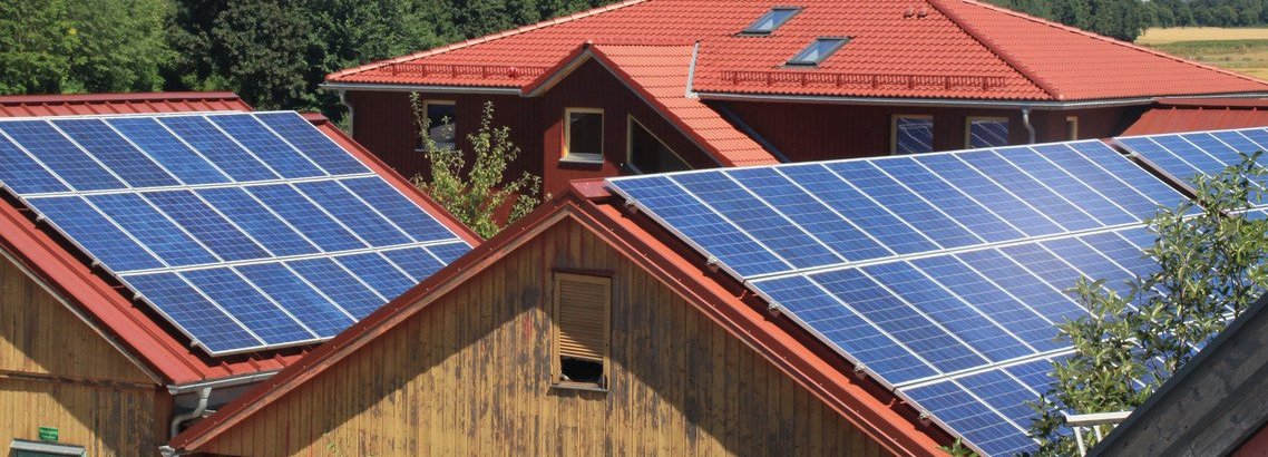 Beschreibung:Solarzellen auf den Dächern von zwei Holzhütten 