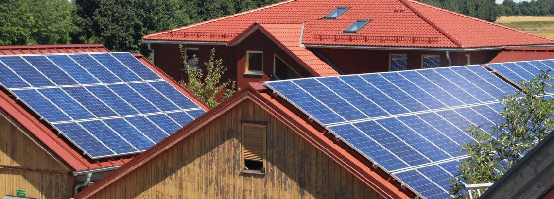 Solarzellen auf den Dächern von zwei Holzhütten 