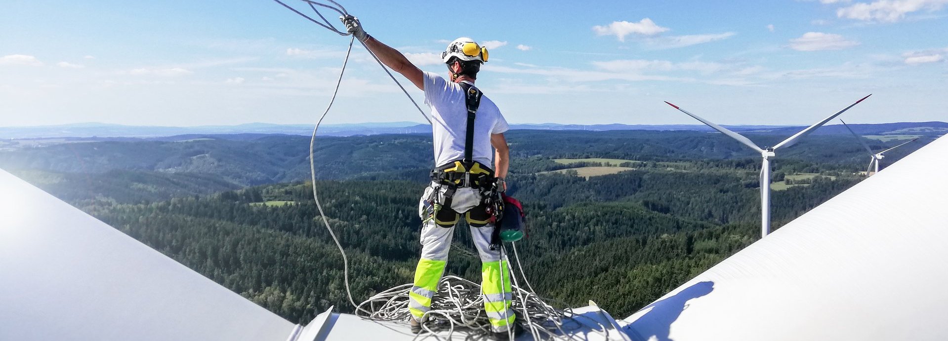 Monteur auf einem Windrad wirft Seil