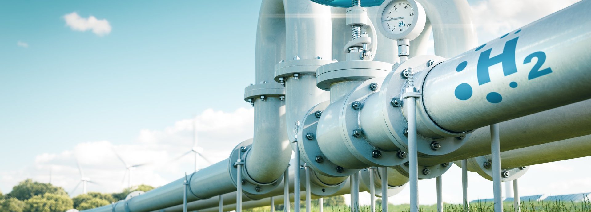 Beschreibung: Rohr mit Wasserstoff auf einer grünen Wiese und vor blauem Himmel