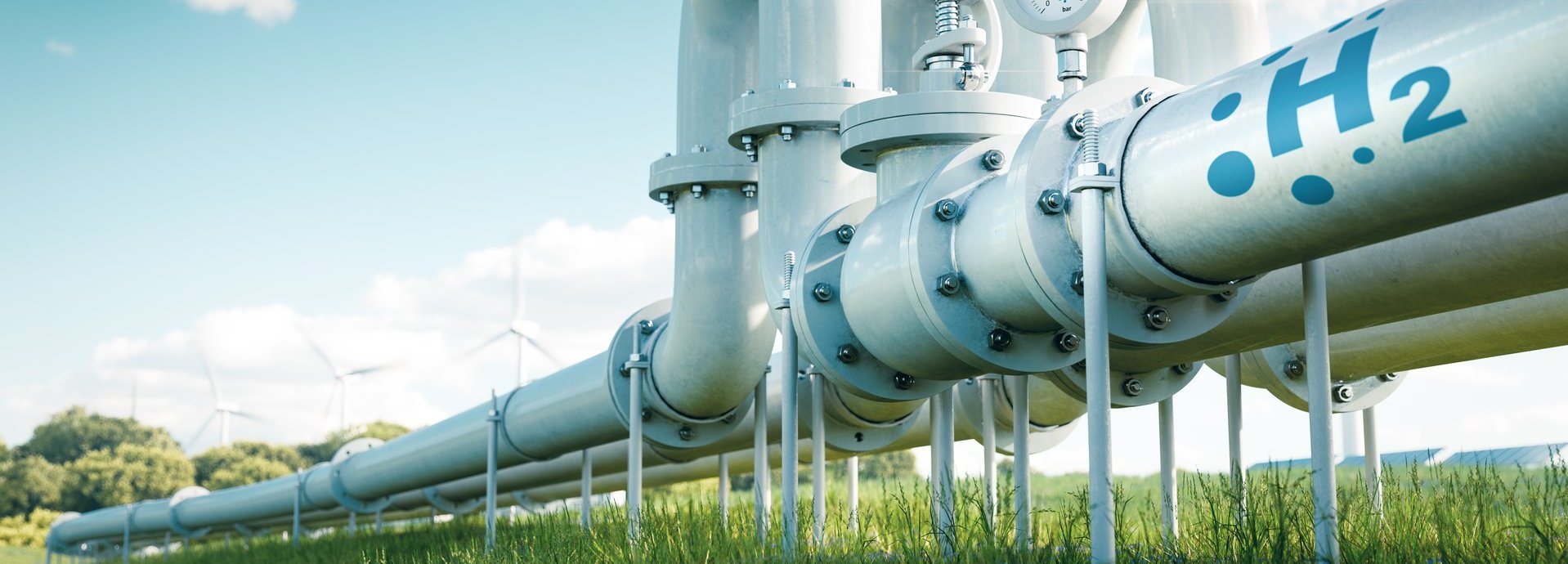 Beschreibung: Rohr mit Wasserstoff auf einer grünen Wiese und vor blauem Himmel