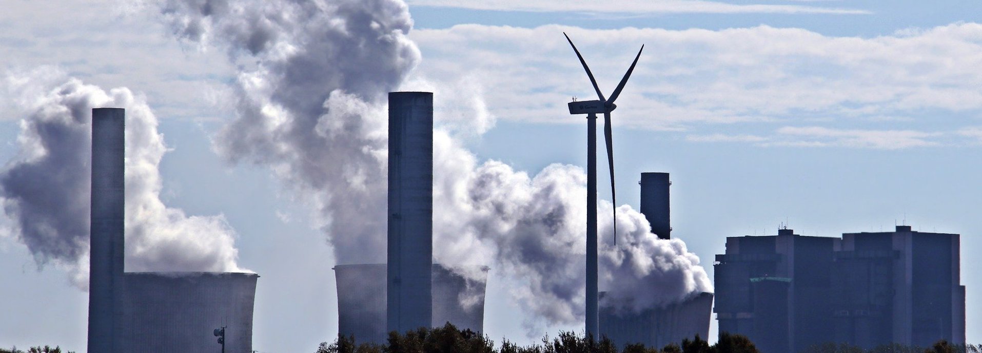 Kohlekraftwerk stößt Qualm am Horizont aus mit einem einzigen Windrad dazwischen