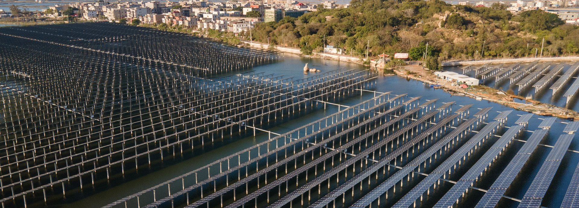 Solarkollektoren auf einem Gewässer in der Nähe einer Siedlung