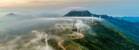 Windräder stehen an einer Straße auf einem hohen Gebirge 