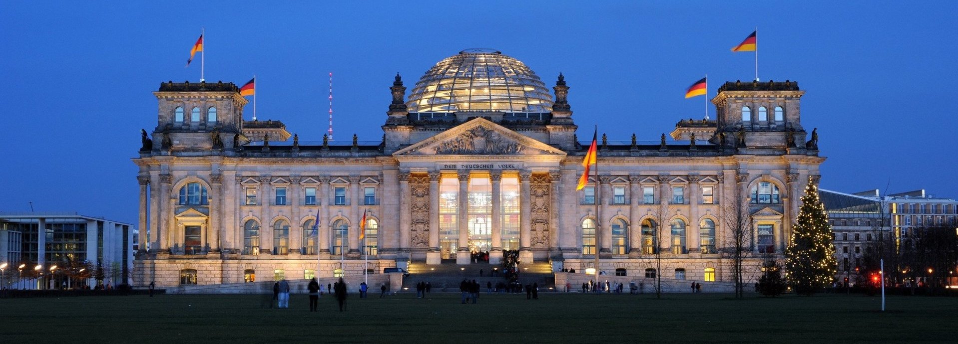 Angeleuchtetes Bundestagsgebäude vor dunkelblauem Himmel