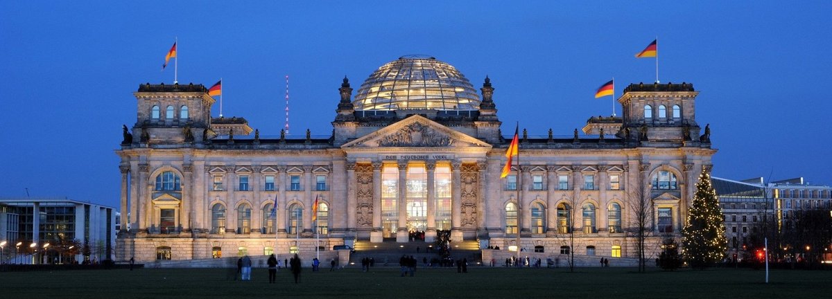 Angeleuchtetes Bundestagsgebäude vor dunkelblauem Himmel