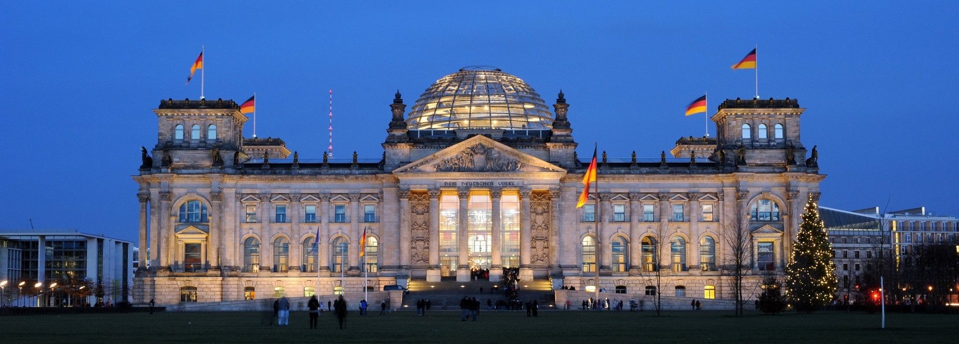 Angeleuchtetes Bundestagsgebäude vor dunkelblauem Himmel