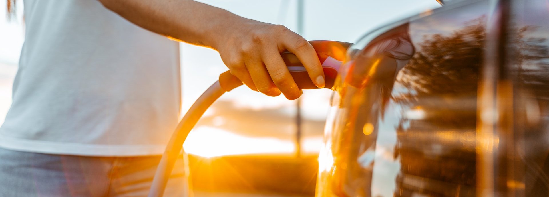 Beschreibung: Person lädt Elektroauto