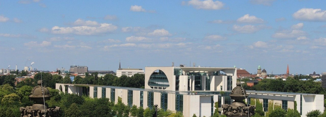 Bundeskanzleramt aus Entfernung mit Deutschlandflagge im Vordergrund