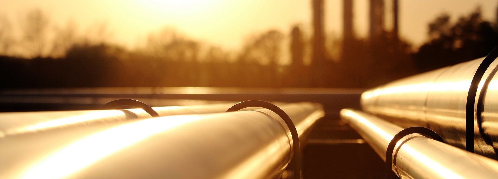 Beschreibung: Goldenes Stahlrohrnetz in der Rohölraffinerie bei goldenem Sonnenlicht