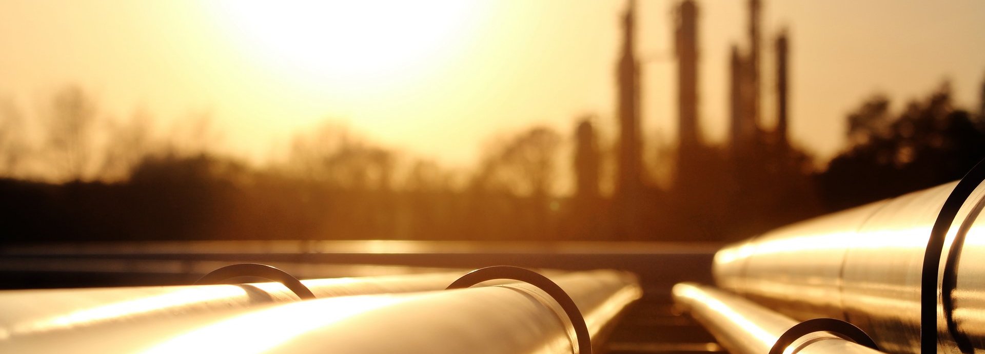 Beschreibung: Goldenes Stahlrohrnetz in der Rohölraffinerie bei goldenem Sonnenlicht