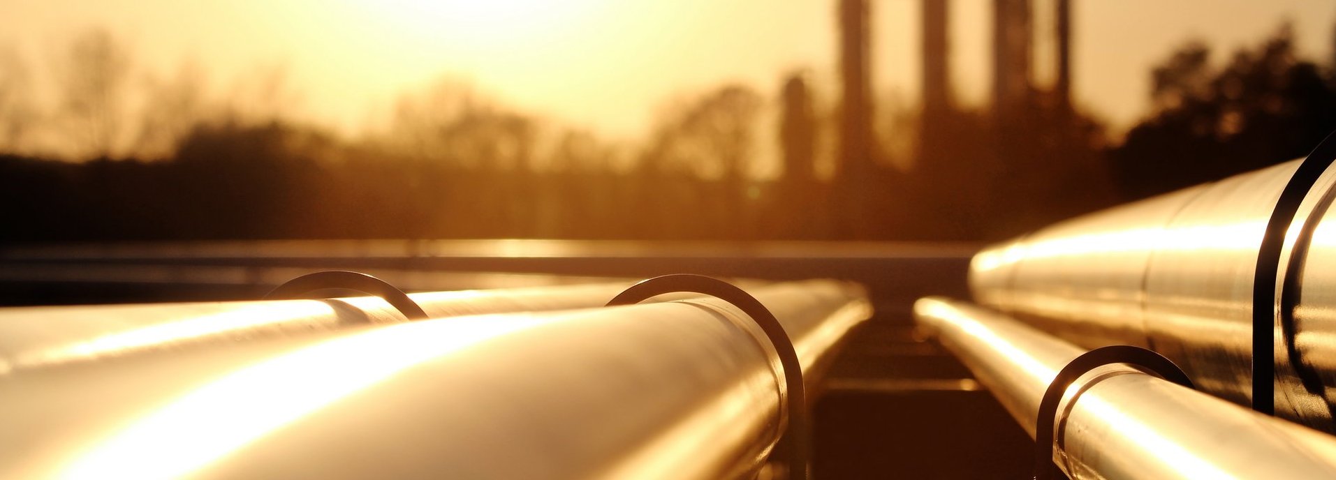 Goldenes Stahlrohrnetz in der Rohölraffinerie bei goldenem Sonnenlicht