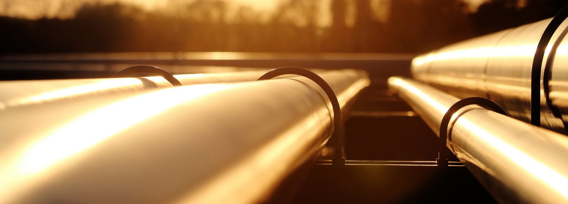 Goldenes Stahlrohrnetz in der Rohölraffinerie bei goldenem Sonnenlicht