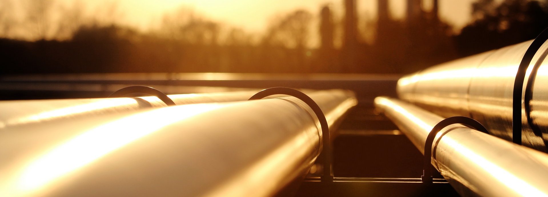 Beschreibung: Goldenes Stahlrohrnetz in der Rohölraffinerie bei goldenem Sonnenlicht