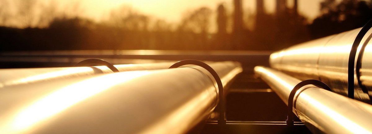 Bildbeschreibung: Goldenes Stahlrohrnetz in der Rohölraffinerie bei goldenem Sonnenlicht