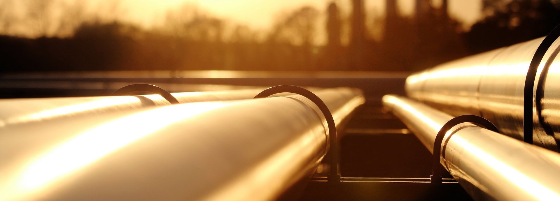 Beschreibung: Goldenes Stahlrohrnetz in der Rohölraffinerie bei goldenem Sonnenlicht