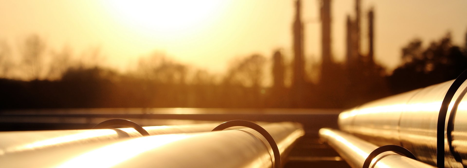 Beschreibung: Goldenes Stahlrohrnetz in der Rohölraffinerie bei goldenem Sonnenlicht